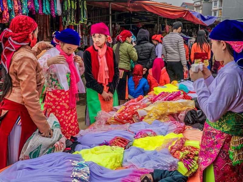 dong van market 2 Colourful ethnic woman browsing clothes at the Dong Van Market
