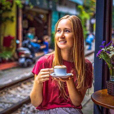 A woman drinking Vietnamese Egg Coffee in Hanoi Train Street