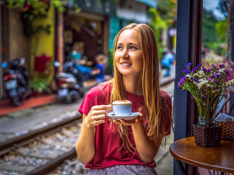 A woman drinking Vietnamese Egg Coffee in Hanoi Train Street
