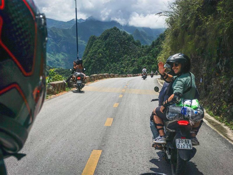 ha giang loop easy rider tour motorbike 1 Ha Giang Loop motorbike tour with traveler on the back of an Easy Rider riding along a scenic mountain road