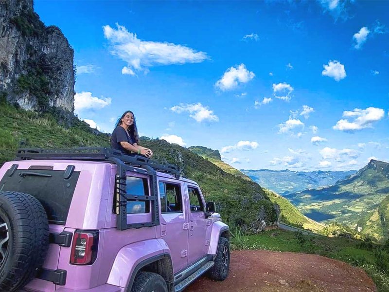 ha giang loop jeep tour 1 Girl sitting on top of a jeep with panoramic views of Ha Giang mountains