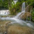 Hieu Waterfall tours with cascading limestone pools and clear turquoise water in Pu Luong