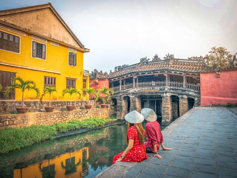 hoi an romantic couple ancient town 1 A couple sitting next to the Japanese Bridge in Hoi An for a romantic time in Vietnam