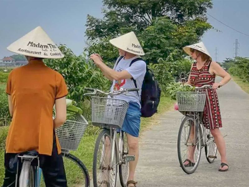 hue countryside cycling tour 1 Travelers stopping to pick herbs and vegetables while cycling through Hue’s countryside villages.