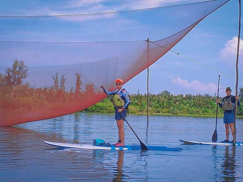 kayaking tour hoi an mangrove forest 12 SUP travelers paddling near a giant Vietnamese fishing net along the waterways of Hoi An