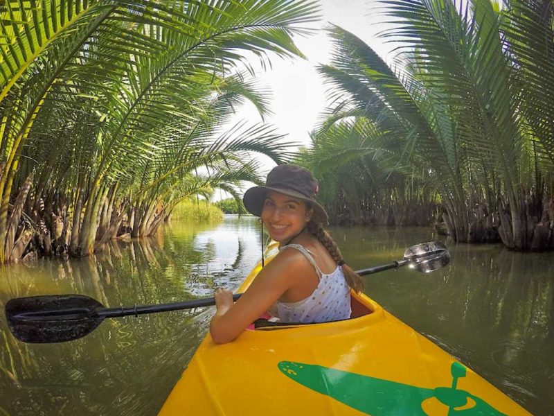 kayaking tour hoi an mangrove forest 2 Smiling traveler kayaking through a tunnel of nipa palms in the Hoi An mangrove forest