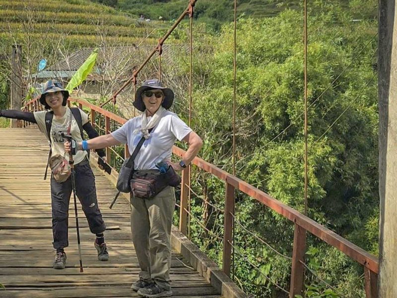 mu cang chai tour 10 Mu Cang Chai trekking tour with two travelers crossing a wooden suspension bridge in the mountains