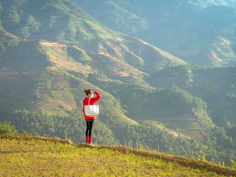 overlooking san nhu village mu cang chai 1 Viewpoint overlooking San Nhu Village in Mu Cang Chai with a traveler enjoying the mountain landscape