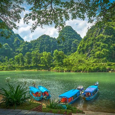 Boats docked on the river banks near Phong Nha Cave