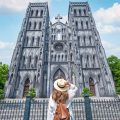 Tourist at St. Joseph's Cathedral: A woman admires the architectural details of St. Joseph's Cathedral in Hanoi.