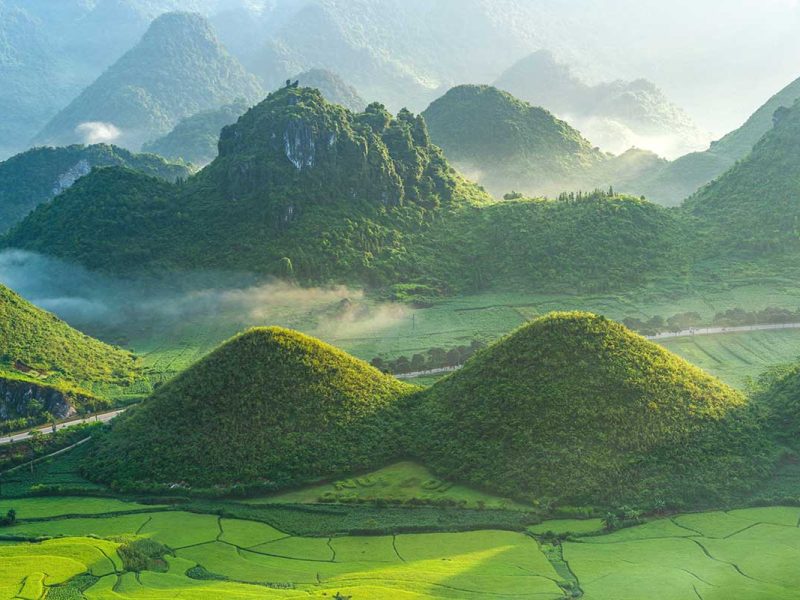 twin mountains quan ba 2 A panoramic view of the Twin Mountains in Quan Ba, Ha Giang, surrounded by lush green rice fields.